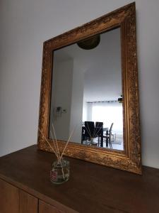 een spiegel bovenop een dressoir bij Cosy'part Gold. in Bezons