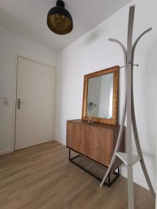 een woonkamer met een spiegel en een dressoir bij Cosy'part Gold. in Bezons
