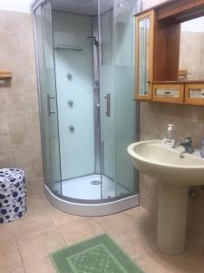 ein Bad mit einer Glasdusche und einem Waschbecken in der Unterkunft Appartamento luminoso e spazioso al primo piano in Capoterra