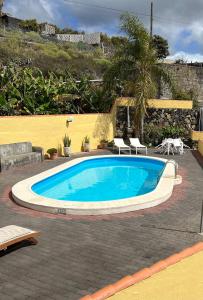 una piscina in un cortile con due sedie di Casa Agustín a Los Llanos de Aridane