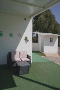 a couch sitting on a porch with a green carpet at VILLA PEPUCHO 3 in Almodóvar del Río