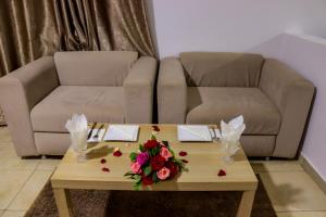 uma sala de estar com um sofá e uma mesa de centro com flores em HOTEL BORJ SAFAE LAAYOUNE em Laayoune