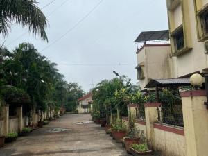 an empty street with trees and a building at Homely condo in Lonavala in Lonavala