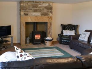 a living room with a couch and a fireplace at Grangemoor Barn in Rothley