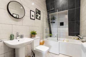 a bathroom with a sink and a toilet and a tub at Modern 1 Bed Apartment, Sea Views, free parking, wifi, netflix in Teignmouth