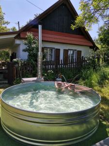 two people in a hot tub in front of a house at Keltike apartman in Nagybörzsöny