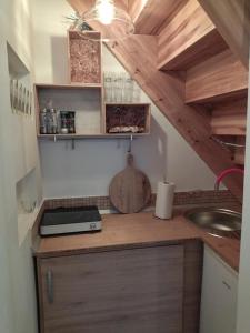 eine Küche mit einer Theke mit einer Spüle und Holzschränken in der Unterkunft Keltike apartman in Nagybörzsöny