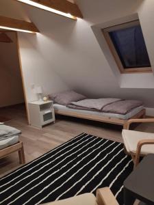 Habitación con cama y alfombra en el suelo en Keltike apartman en Nagybörzsöny