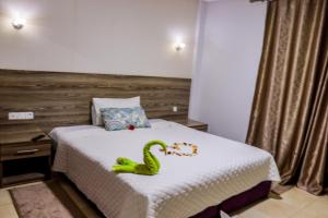 um quarto com uma cama com uma cobra de brinquedo em HOTEL BORJ SAFAE LAAYOUNE em Laayoune