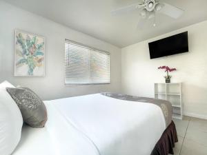 a bedroom with a large white bed and a flat screen tv at The Starfish in Hollywood