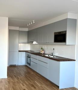 a kitchen with white cabinets and a black counter top at Private room in Hammarby Sjöstad, common space shared! in Stockholm