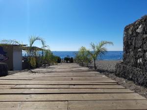 un chemin menant à la plage avec l'océan en arrière-plan dans l'établissement Sun House Sicily, à Mascali