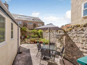 a patio with a table and chairs and an umbrella at The Parade in Berwick-Upon-Tweed