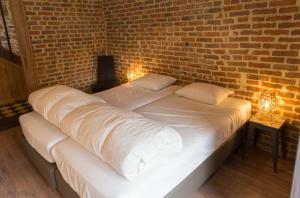 a large bed in a room with a brick wall at Gite Kooa Prestige in Theux