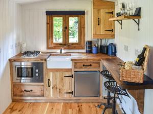 a small kitchen with wooden cabinets and a sink at Keldholme Shepherds Hut in Kirkbymoorside