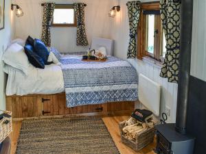 a bedroom with a bed in a tiny house at Keldholme Shepherds Hut in Kirkbymoorside