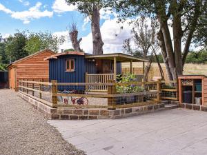 a tiny house with a porch and a fence at Keldholme Shepherds Hut in Kirkbymoorside