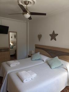 1 dormitorio con 2 camas y toallas. en CALIFAL, en Córdoba