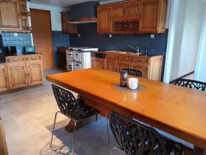 a large kitchen with a wooden table and chairs at Ô Valanvron - Appartement dans une ancienne ferme neuchâteloise in La Chaux-de-Fonds