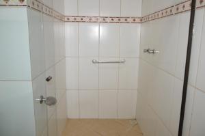 a bathroom with a shower with white tiled walls at Hotel Colonial in Pôrto Real