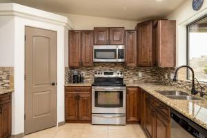 a kitchen with wooden cabinets and stainless steel appliances at Heated Pool & Spa - Winterhavens Oasis in Lake Havasu City