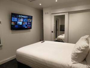 1 dormitorio con 1 cama y TV en la pared en The Annex en Bristol