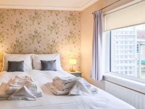 um quarto com uma cama com lençóis brancos e uma janela em Marrion House em Middleton