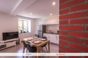 a kitchen and dining room with a red brick wall at Maison Planté a1 in Argelès-Gazost