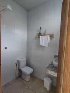 a white bathroom with a toilet and a sink at Dom Jaime - Guest House in Pirenópolis