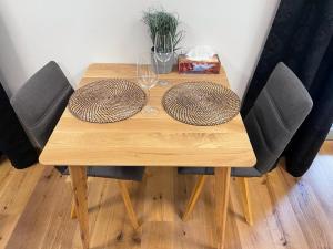 een houten tafel met twee borden en glazen erop bij Luxury apartment Trio Harrachov A.2 in Harrachov