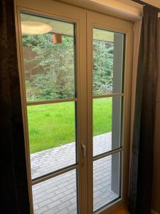 een glazen deur met uitzicht op een tuin bij Luxury apartment Trio Harrachov A.2 in Harrachov