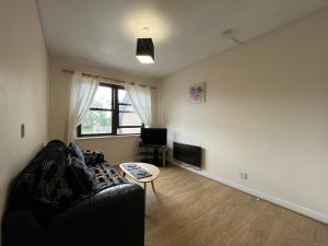 a living room with a black couch and a table at River View Apartment in Elgin