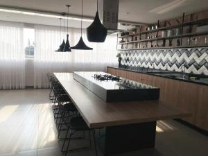 uma cozinha com uma grande mesa de madeira e cadeiras em Apartamento Wi-fi, Split, Estacionamento e Piscina em Ribeirão Preto