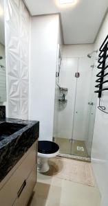a bathroom with a toilet and a glass shower at Apto Encantador Próximo ao Centro de Gramado in Gramado