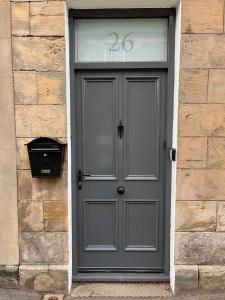 una puerta gris con el número en un edificio en Number Twenty Six - 2 miles from Elie Beach - 15mins to St Andrews en Colinsburgh