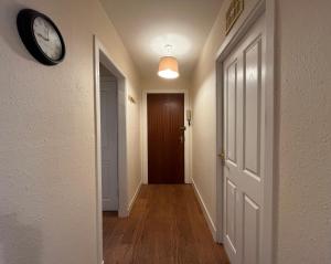 a hallway with a clock on the wall and a door at Elgin apartment in Elgin
