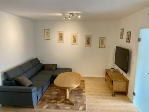 sala de estar con sofá azul y mesa en Ferienwohnung Brunnenblick 