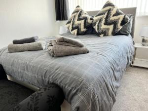 a bed with pillows and towels on top of it at Seaside 2 bedroom house with large garden in Rhyl