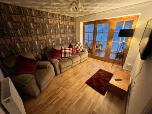 uma sala de estar com um sofá e uma mesa em Seaside 2 bedroom house with large garden em Rhyl