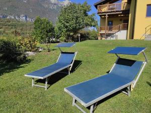 three picnic tables on the grass in front of a house at Villa Villi in Terlago