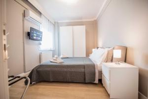 ein kleines Schlafzimmer mit einem Bett und einem Fenster in der Unterkunft Axd DownTown Spacious Lux Apartment in Alexandroupoli