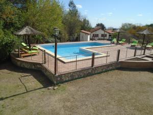 basen z ogrodzeniem wokół niego w obiekcie Aldea Blanca w mieście Merlo