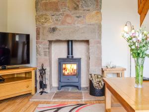 a living room with a fireplace with a tv at Woodside in Blairgowrie