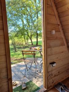 a door leading to a patio with a table in a cabin at Wolf & Sheep Nature & Adventure in Podgorica