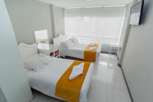 ein Hotelzimmer mit 2 Betten und einem Spiegel in der Unterkunft ApartaSuites & Hotel Bogota Suamox in Bogotá