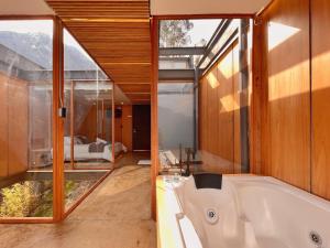 a bathroom with a tub and a large window at Deluxe volcán Primeras suites colgantes del mundo in Baños