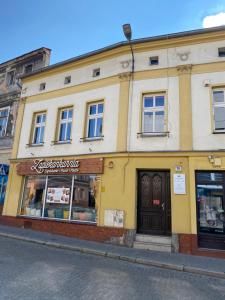 un edificio amarillo al lado de una calle en Apartament Jedności, en Zielona Góra