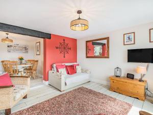 a living room with a couch and a tv at Quay End in Reedham