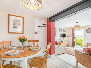 a dining room and living room with a table and chairs at Quay End in Reedham