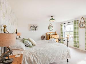 a bedroom with a bed and a clock on the wall at Quay End in Reedham
